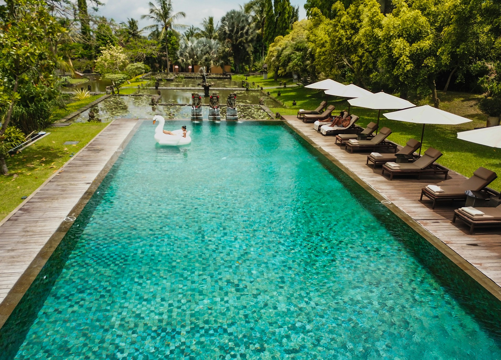 Resort pool with Sukabumi stone, wooden deck and luxury lounge chairs